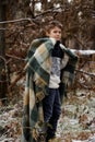 One boy in plaid walks in the snow in the autumn forest. alone i