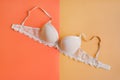 One bra of beige color on pastel orange and yellow background Royalty Free Stock Photo