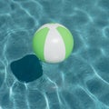 Close-up one bright green beach ball in swimming pool sunny day Royalty Free Stock Photo