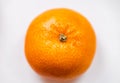 One bright ripe orange glossy tangerine in orange peel on white background. Top view. Close-up Royalty Free Stock Photo