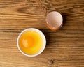 One Broken Egg in Black Bowl, Raw Yolk and White, Fresh Broken Organic Chicken Egg Royalty Free Stock Photo