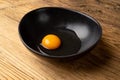 One Broken Egg in Black Bowl, Raw Yolk and White, Fresh Broken Organic Chicken Egg Royalty Free Stock Photo