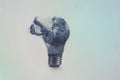 One broken light bulb on a blue background with smoke. Overdue idea concept