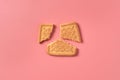 One broken square cookie lies on pink desk on kitchen