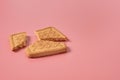 One broken square cookie lies on pink desk on kitchen