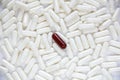 One brown dissimilar capsule lie on a white capsules Royalty Free Stock Photo
