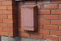 One brown metal mailbox hanging on a red brick wall Royalty Free Stock Photo