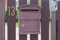 One brown metal mailbox on a wooden fence from boards Royalty Free Stock Photo