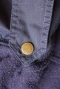 one brown metal rivet button on blue fabric