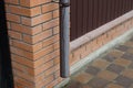 One brown plastic gutter pipe on a brick wall Royalty Free Stock Photo