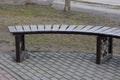 One brown wooden bench stands on a gray sidewalk Royalty Free Stock Photo