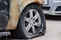 Burned flat tire on the car is on the gray asphalt road Royalty Free Stock Photo