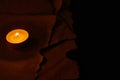 One burning circle candle and ancient burnt paper sheets Royalty Free Stock Photo