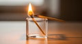 One burning match ignites another, symbolizing connection and ideas in a glass holder Royalty Free Stock Photo