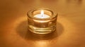 One Burning Tea Light Candle on Gold Royalty Free Stock Photo