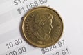 One Canadian dollar coin on top of banking statement Royalty Free Stock Photo