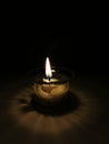 One candle light burning brightly on dark background. Royalty Free Stock Photo