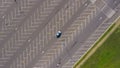 The lone car is moving on Huge Empty parking lot with lots of empty parking spaces during quarantine during the Covid-19 virus Royalty Free Stock Photo