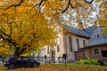 One car parked under a tree in the courtyard of the Oslo Cathedral in the autumn The trees in the garden