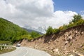 One car on a serpentine road in the mountains, mountain peaks in the snow and green hills background Royalty Free Stock Photo