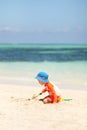 One caucasian boy playing with sand at tropical beach Royalty Free Stock Photo