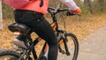 One caucasian children rides bike road in autumn park. Little girl riding black orange cycle in forest. Kid goes do Royalty Free Stock Photo