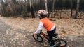 One caucasian children rides bike road in autumn park. Little girl riding black orange cycle in forest. Kid goes do Royalty Free Stock Photo