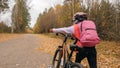 One caucasian children walk with bike in autumn park. Little girl walking black orange cycle in forest. Kid goes do Royalty Free Stock Photo