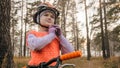 One caucasian children walk with bike in autumn park. Little girl walking black orange cycle in forest. Kid goes do Royalty Free Stock Photo