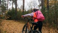 One caucasian children walk with bike in autumn park. Little girl walking black orange cycle in forest. Kid goes do bicycle sports Royalty Free Stock Photo