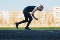 One caucasian male is doing a sprint start. running on the stadium on a rubber track. Track and field runner in sport uniform. Royalty Free Stock Photo