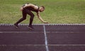 One caucasian male is doing a sprint start. running on the stadium on a rubber track. Track and field runner in sport uniform. Royalty Free Stock Photo