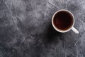 One ceramic cup with hot black tea, drink in white teacup on textured dark stone background Royalty Free Stock Photo