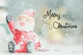 One ceramic santa claus Merry Christmas text on snowfall background. Royalty Free Stock Photo