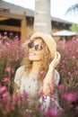 One cheerful happy young adult woman sitting in the middle of pink flowers enjoying spring and outdoor leisure activity in the Royalty Free Stock Photo