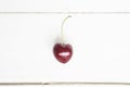 One cherry in the shape of a heart. Ripe fresh juicy berry on a white wooden background. Fruit background. valentine Royalty Free Stock Photo