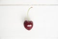 One cherry in the shape of a heart. Ripe fresh juicy berry on a white wooden background. Fruit background. valentine Royalty Free Stock Photo