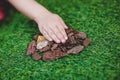 One child`s hand is building something from wood against the background of a green lawn of grass Royalty Free Stock Photo