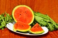 One chopped watermelon in a plate with vegetables on the side Royalty Free Stock Photo