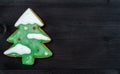 One Christmas fir tree gingerbread cookie with snow and decorations on dark wooden background, top view, flat lay. Holiday food. Royalty Free Stock Photo