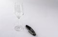 Wineglass and cork opener on white background