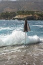 One closed black parasol near the stormy sky. The stormy Greek sea on a sunny day. Greek coastline with mountains Royalty Free Stock Photo