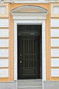 one closed black wooden door on a brown white brick wall Royalty Free Stock Photo