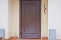 one closed brown metal-plastic door on a gray wall Royalty Free Stock Photo