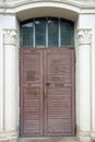 one closed brown wooden old door with a small window Royalty Free Stock Photo