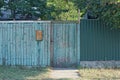 One closed gray green wooden door on a rustic fence Royalty Free Stock Photo