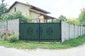 One closed green metal gate with a black wrought iron pattern Royalty Free Stock Photo