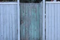 one closed old green door on a gray wooden fence Royalty Free Stock Photo