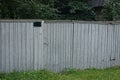 One closed wooden door on the gray wall of a rural fence Royalty Free Stock Photo