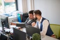 One colleagues showing to another content on computer monitor in the office at work. conversation, boss, employee, business